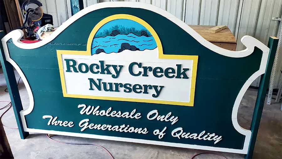 A routed and painted sign finished on the bench in the shop