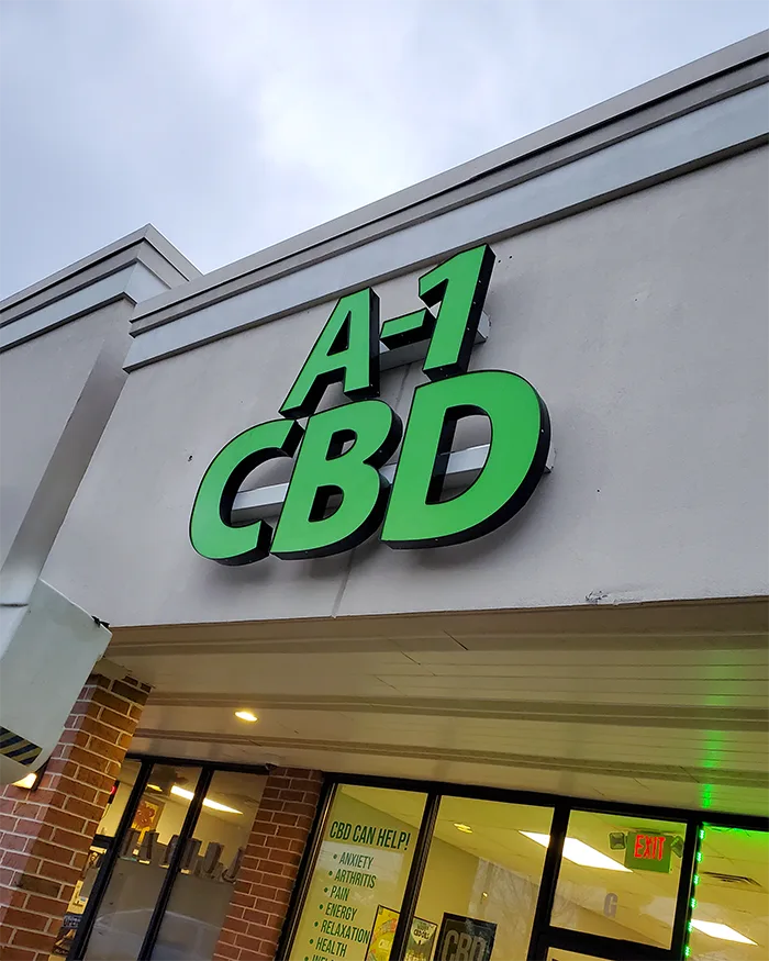 Green channel letters on a raceway over a shop entrance