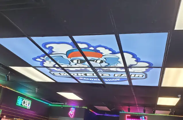 Illuminated ceiling tile indoor signage with Smoker's Fair logo across grid | Indoor Signage | Sparks Sign Company