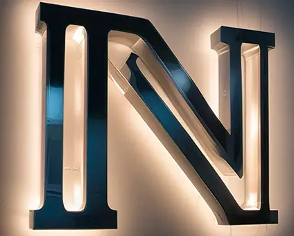 Stainless Steel lettering mounted to wall with backlighting | Monument Signs | Spark Sign Company