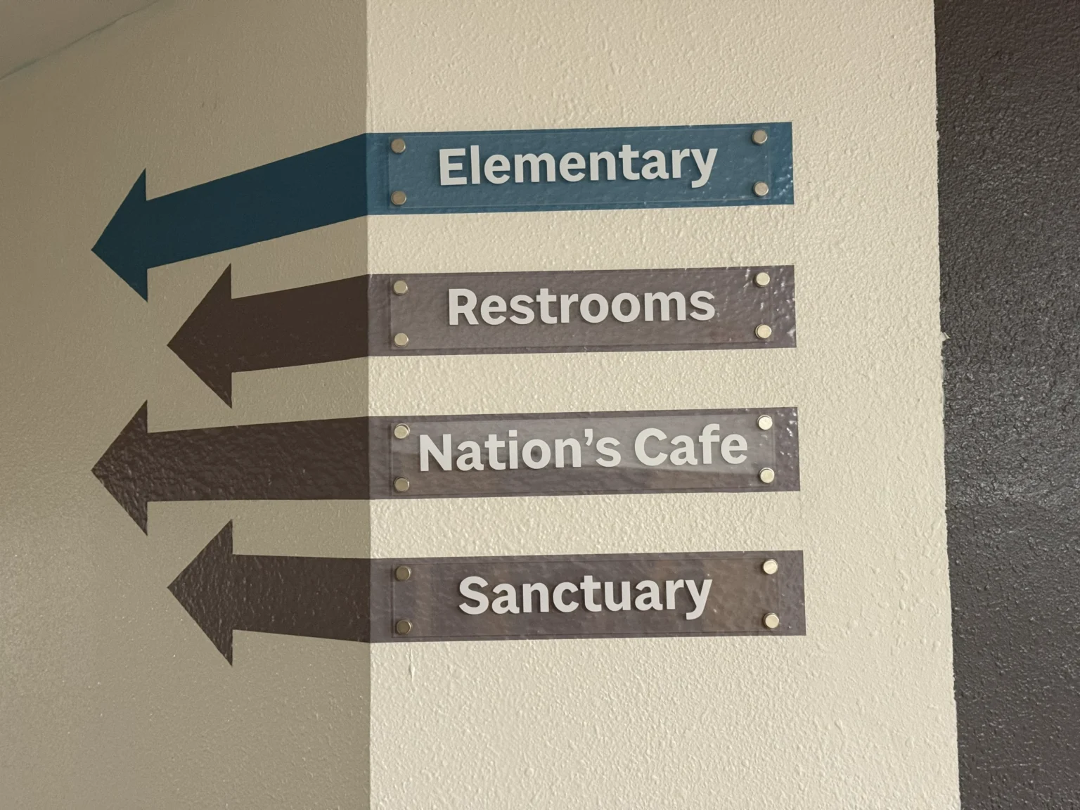 Refuge Kids vinyl wayfinding arrows on a hallway wall