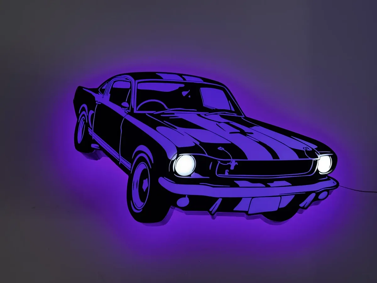 Car silhouette cut-out sign glowing purple on an interior wall, headlights lit