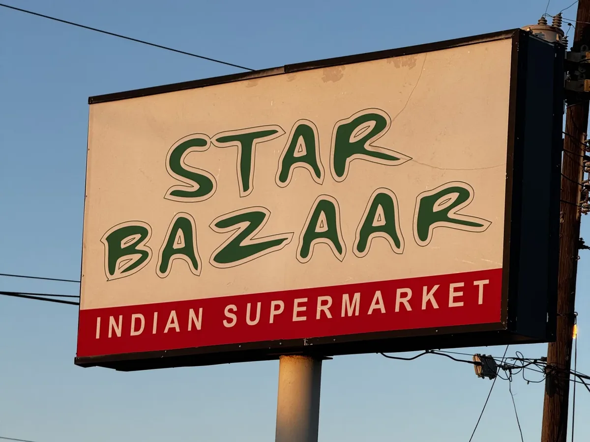 The Star Bazaar Indian Supermarket pylon cabinet on its steel pole, lit by the evening sun