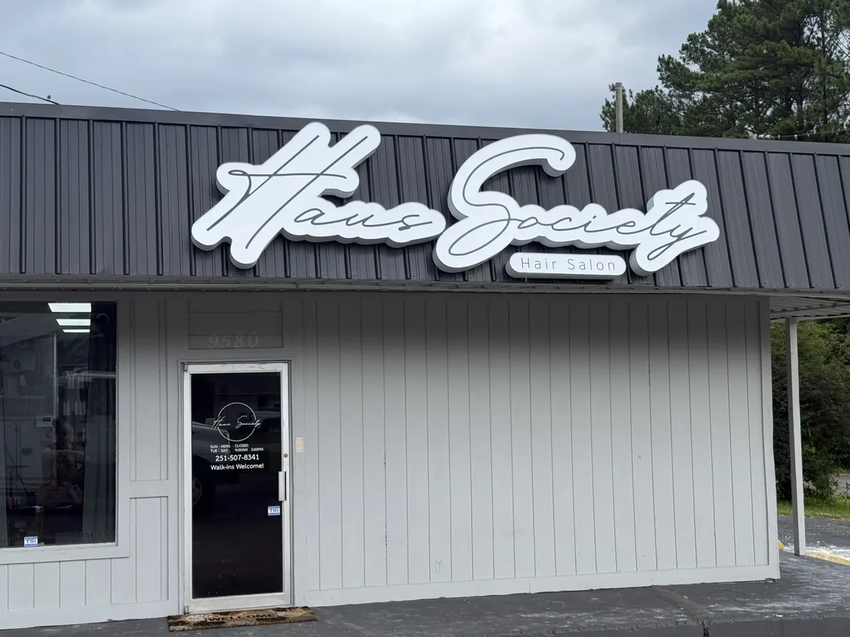 White script Haus Society channel letters with a Hair Salon panel on a salon's grey metal roof fascia