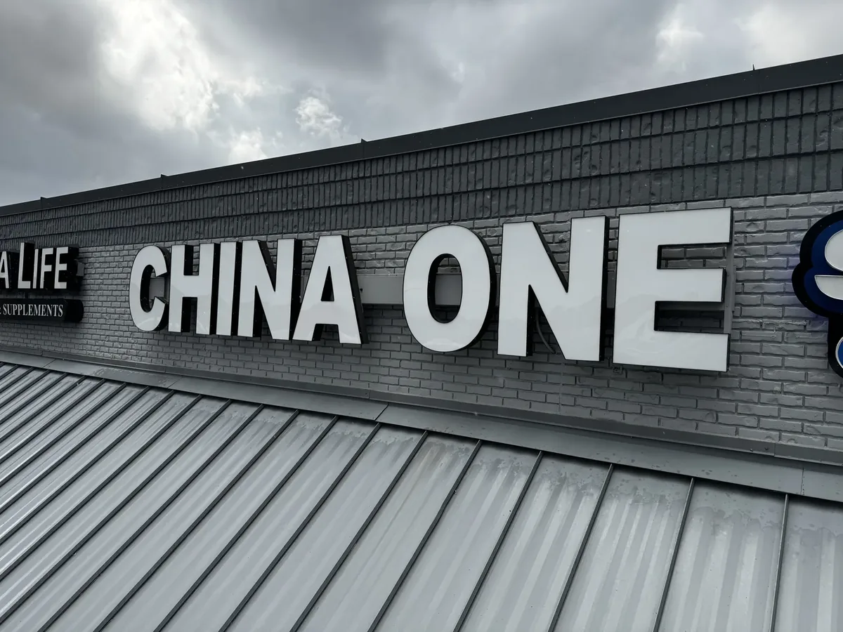 China One white channel letters on a dark brick fascia