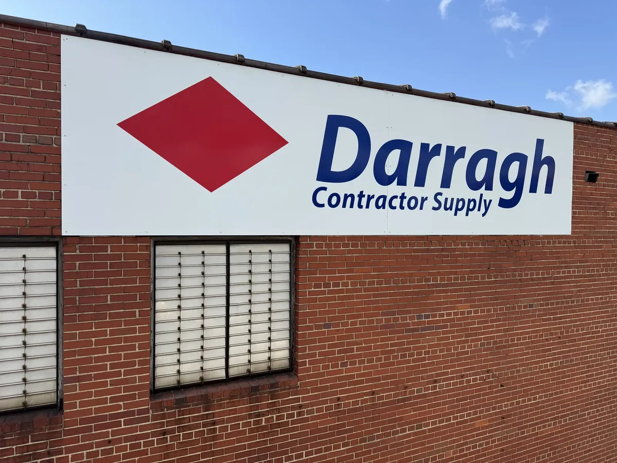 Darragh Contractor Supply flat panel sign with a red diamond on a brick wall