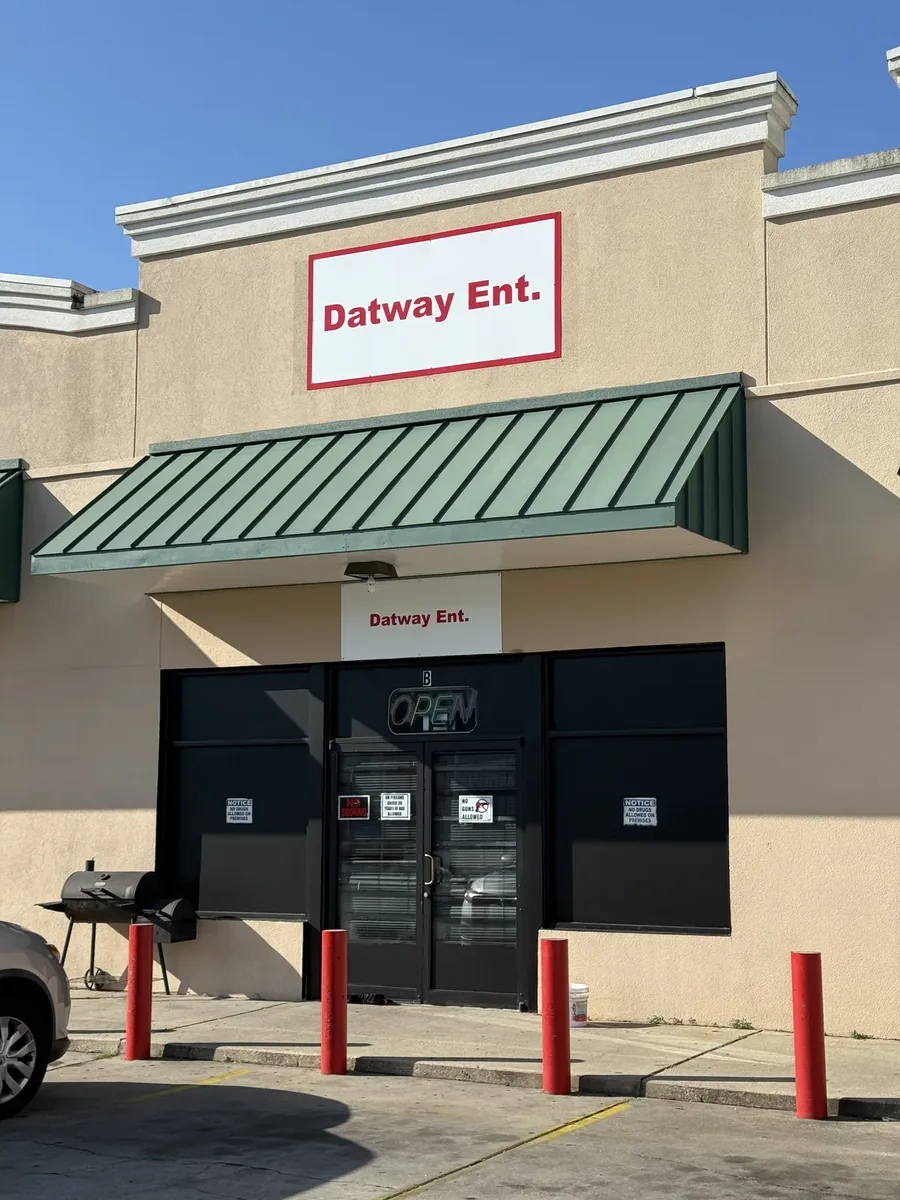 Datway Ent. flat panel sign above a green awning on the storefront