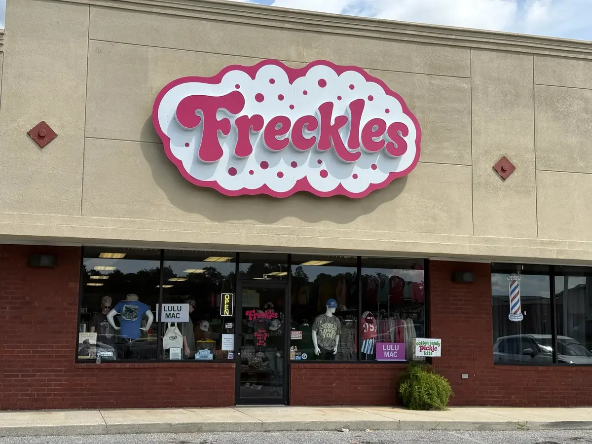 Freckles script channel letters on a pink cloud backer above the storefront