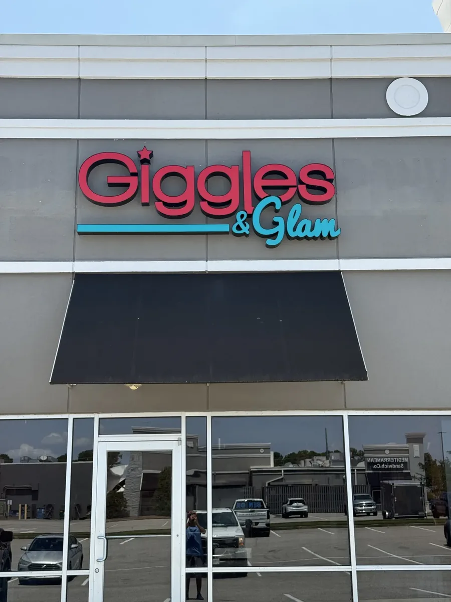Giggles & Glam red and teal channel letters above the storefront awning