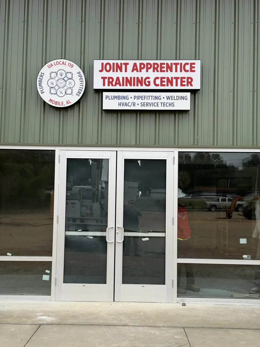 Joint Apprentice Training Center cabinet signs and round logo above the entrance