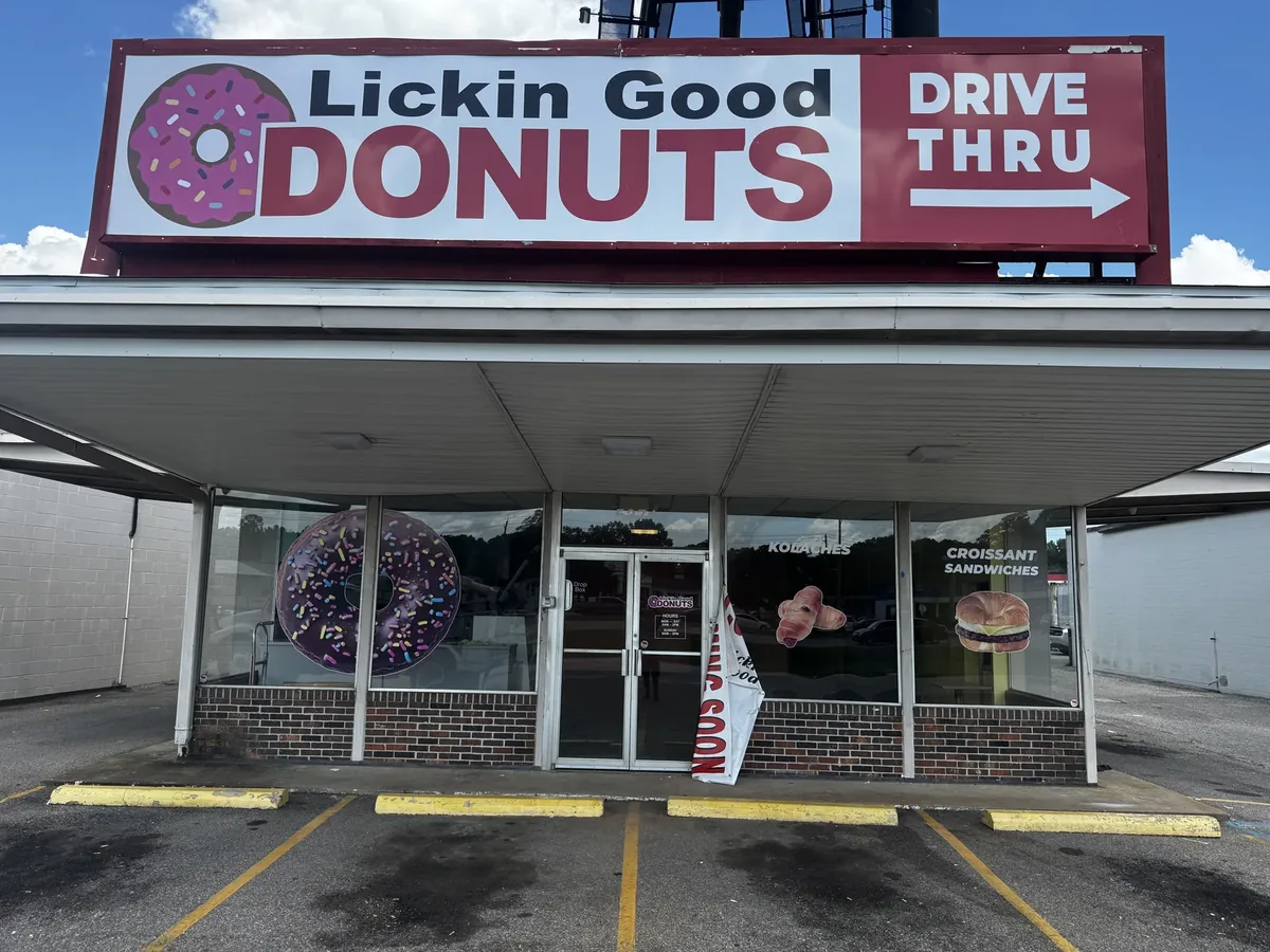 Lickin Good Donuts Drive Thru rooftop sign above the storefront with donut window graphics