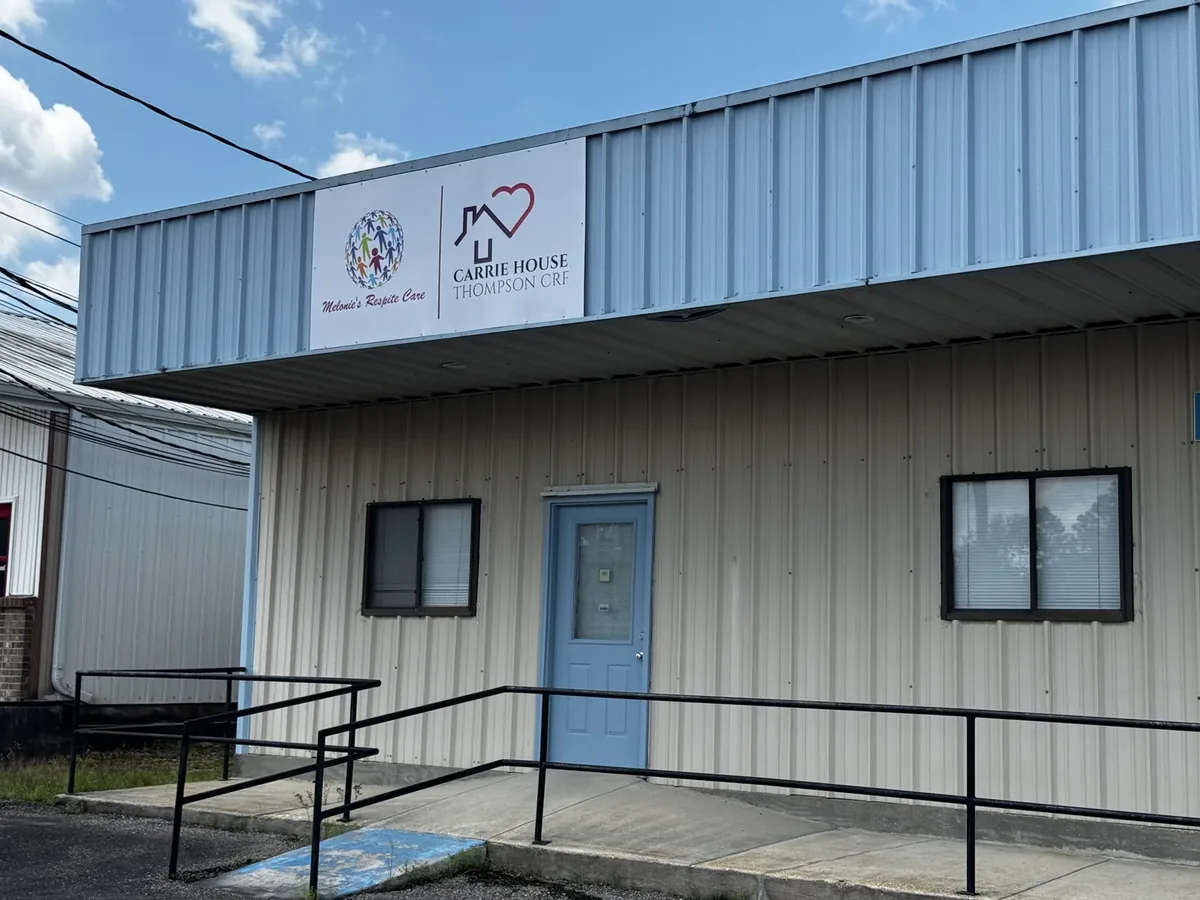 Melonie's Respite Care and Carrie House Thompson CRF flat sign panel above the door of a metal building