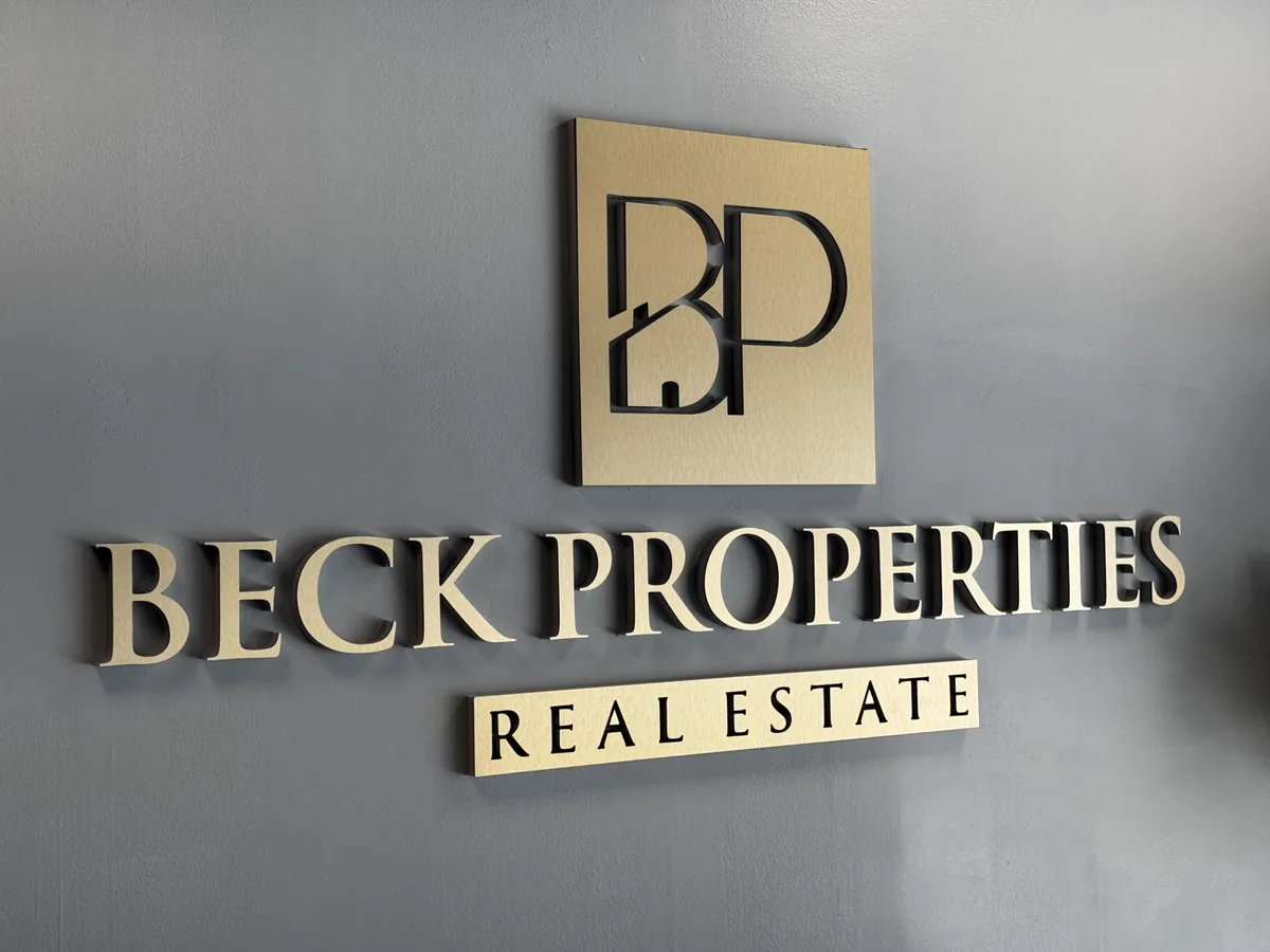 Beck Properties Real Estate logo sign in dimensional letters on a grey lobby wall