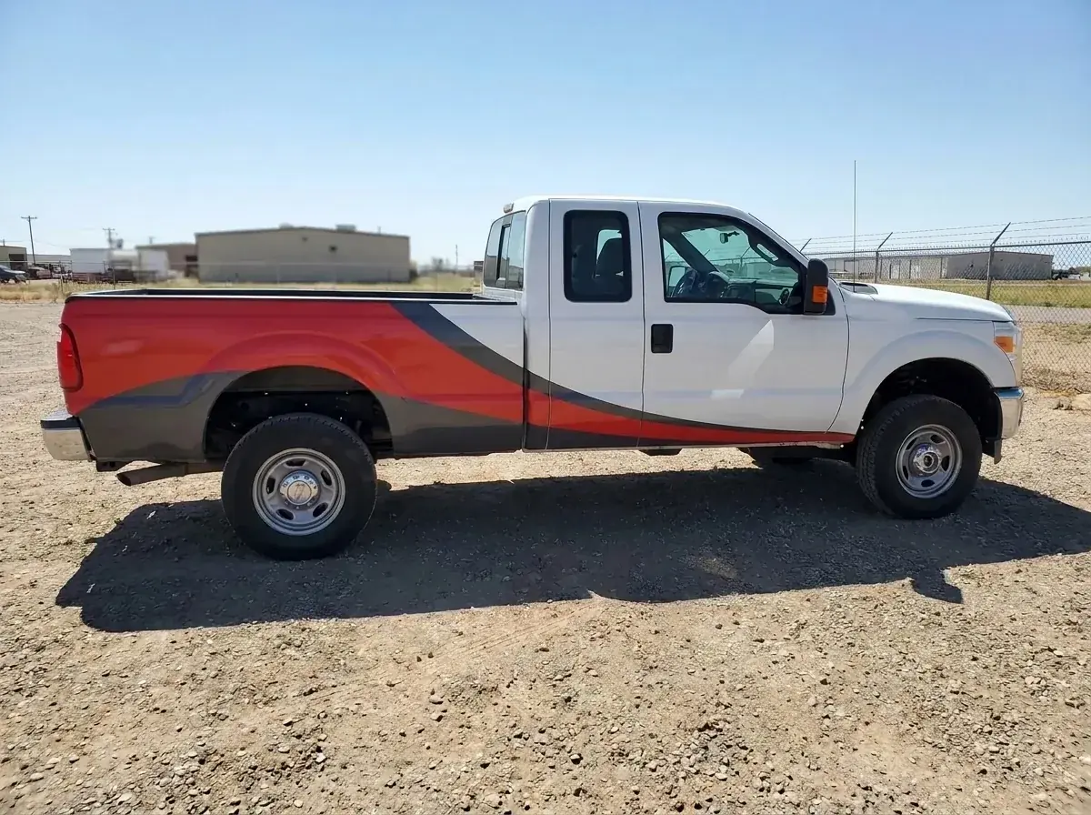 Generated placeholder illustration: a white work pickup truck with a partial wrap of red and charcoal panels over its bed and lower doors