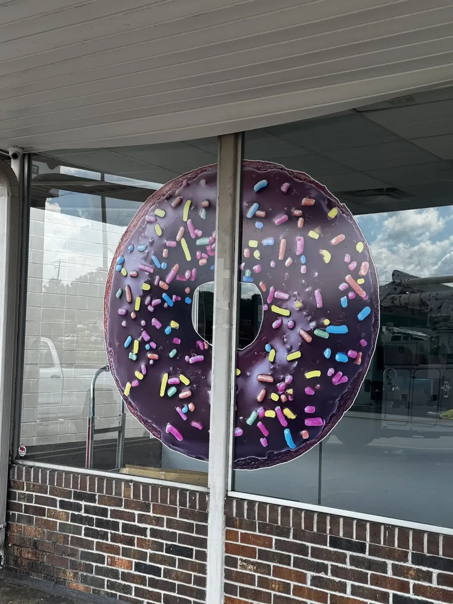 Lickin Good Donuts window decal: a large sprinkled chocolate donut cut in vinyl on the shop's front window