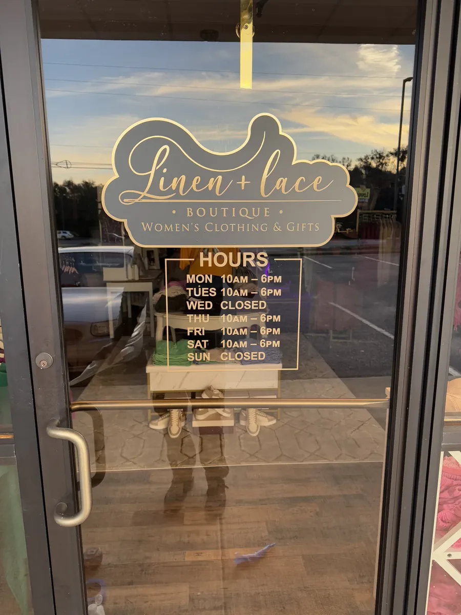 Linen + Lace Boutique logo and opening hours in vinyl lettering on a glass shop door