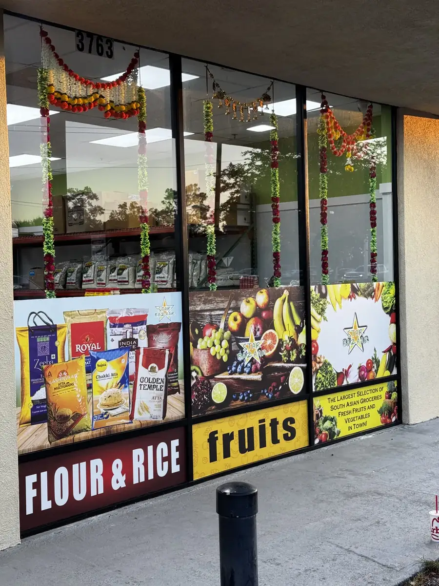 Star Bazaar storefront windows printed with groceries under the words flour and rice, fruits and spices